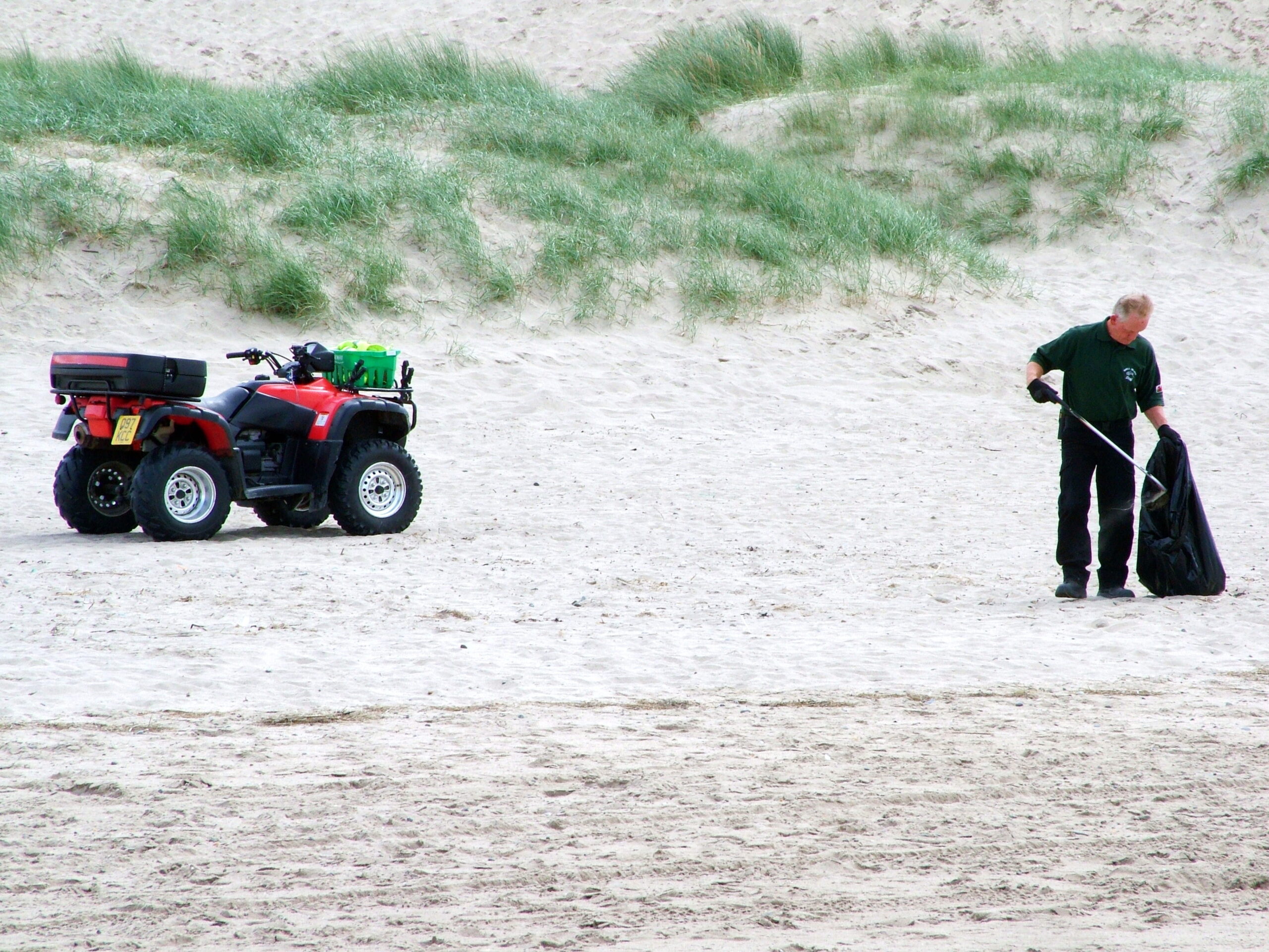 quadbike on beach with map picking litter