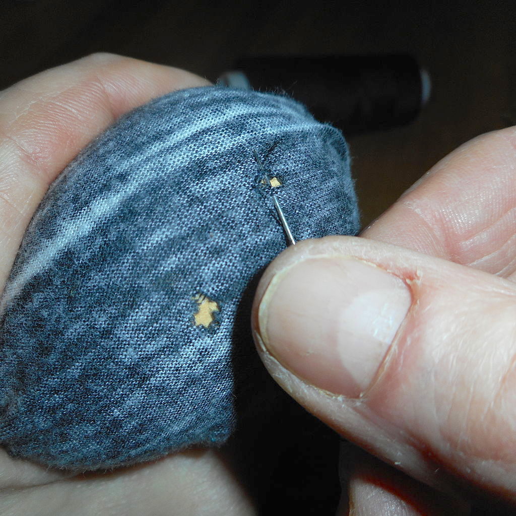 a blue sock being darned