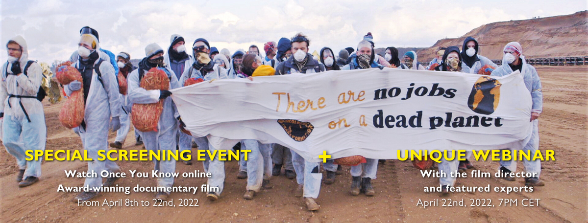 crown of people wearing rpotective clothing carrying a banner