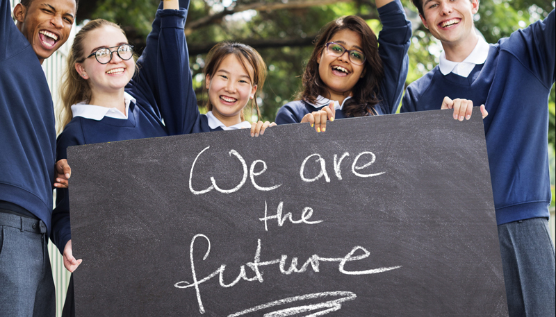 4 children of different ehtnic backgrounds hold a sign saying "We are the future"